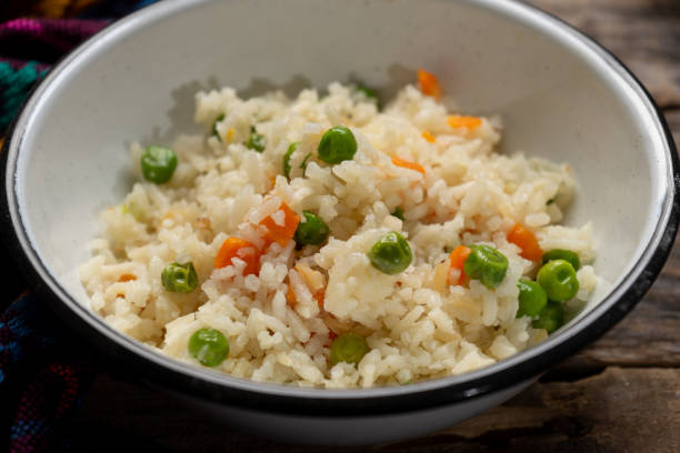 istock White rice with peas and carrot on wooden 1301647807