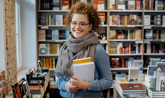 Young woman reading book. Young female student reading book at book store.