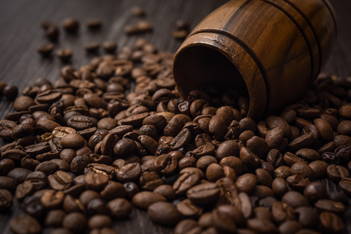 Small brown barrel with roasted coffee beans