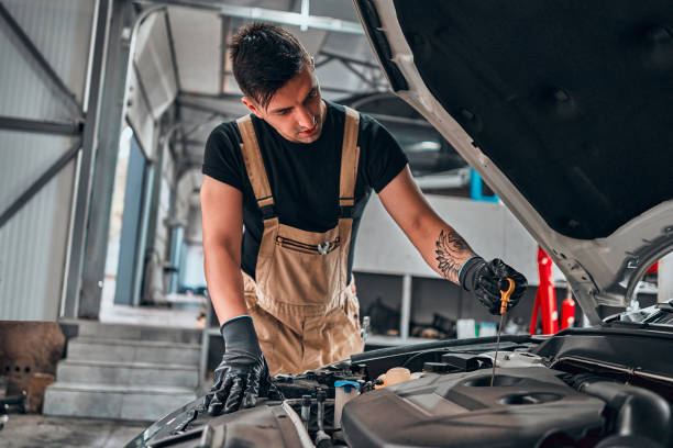 istock Auto mechanic checking oil. Car repair service. 1301650323