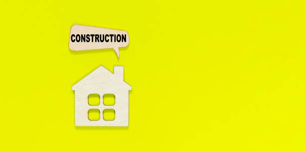 istock House figurine with pop-up window with text construction on yellow background. Under Construction and Building Concept. 1301650908