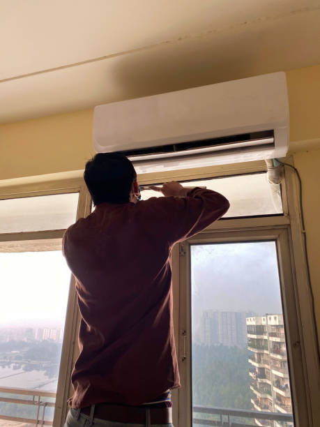 istock Image of Indian handyman fitting a glass pane into a window frame 1301654363