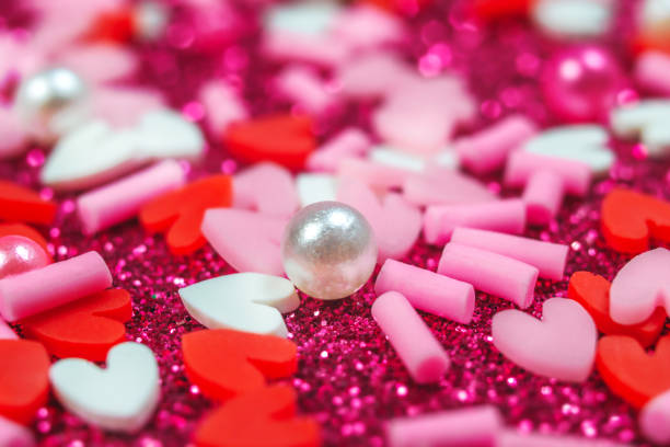 istock Heart candy confetti, pearl on purple sparkle background. Valentines day macro pattern. love wallpaper 1301655643
