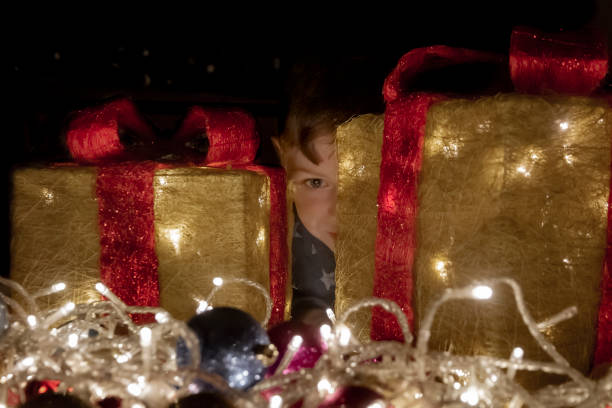 istock Boy hiding behind Christmas decorations 1301659055