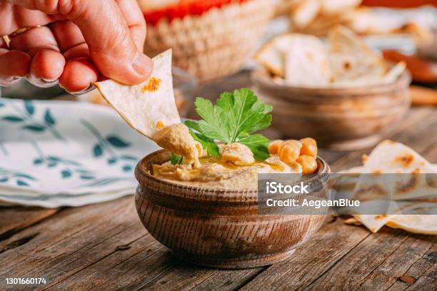 Traditional Vegan Food Hand Dipping Hummus Stock Photo - Download Image Now - Hummus - Food, Pita Bread, Chick-Pea