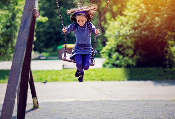 Little girl is swinging in a park