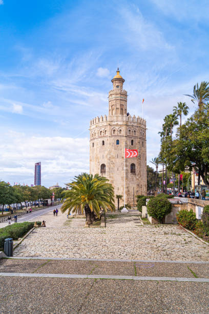 Front view of the Torre del Oro in Seville (Andalusia, Spain). Seville, Spain; February 7th 2021: Front view of the Torre del Oro and the promenade along the Guadalquivir river. Emblematic place of the city with the Torre Sevilla skyscraper in the background. mozarabic stock pictures, royalty-free photos & images