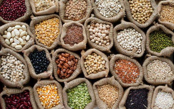 variedad de tipos de cereales naturales y semillas de grano en saco y tono oscuro, para la materia prima de alimentos limpios y el concepto de producto agrícola - arroz grano fotos fotografías e imágenes de stock