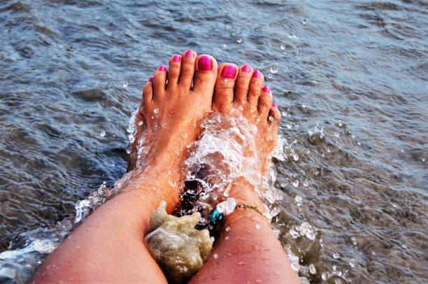 Refreshing legs in sea water by beach on coastline
