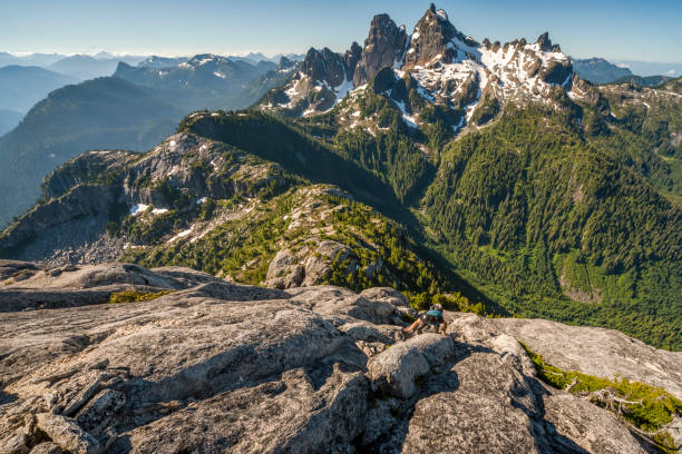 istock Young man climbs up mountain face in the morning 1301677155