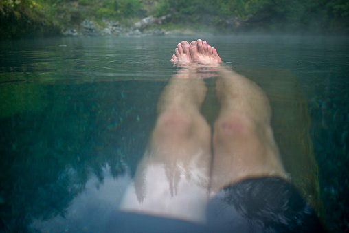 He floats in still blue-green water