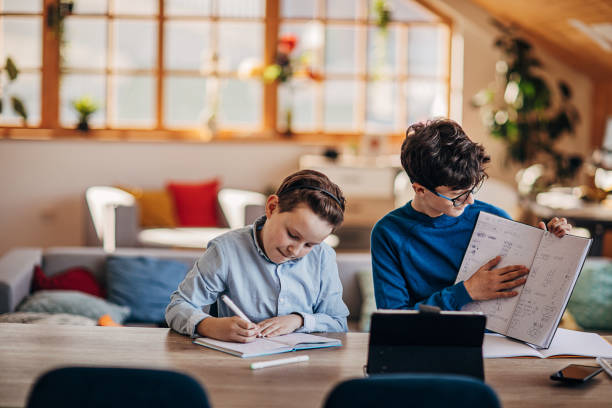 istock Two boys attending online school class from home 1301678473