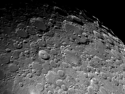 Partly illuminated moon in the dark night sky over Western Europe on January 18, 2024. The surface of the moon is clearly visible with various craters and seas.