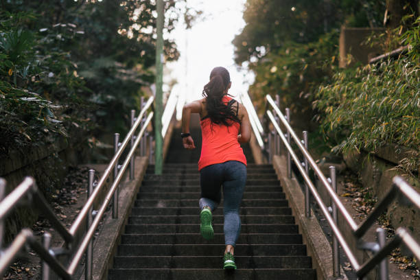 A young female athlete is running up stairs.