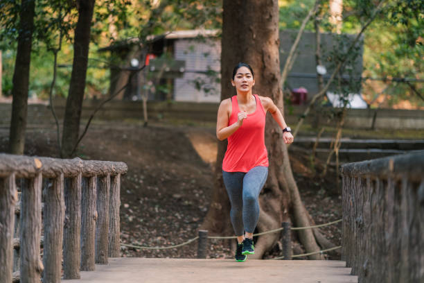 istock Young female athlete running in public park 1301680951
