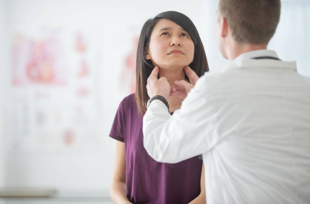 istock Doctor examines patient's throat 1301683541