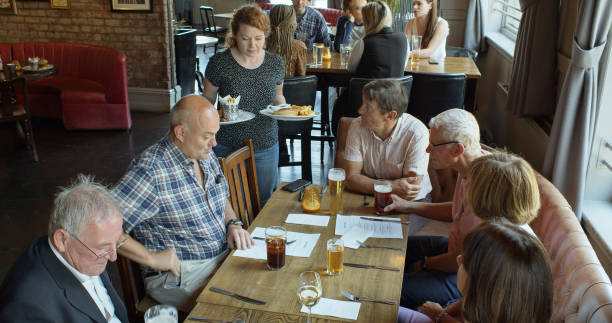 istock Waitress Serving Food to Group Out for Pub Lunch 1301686561