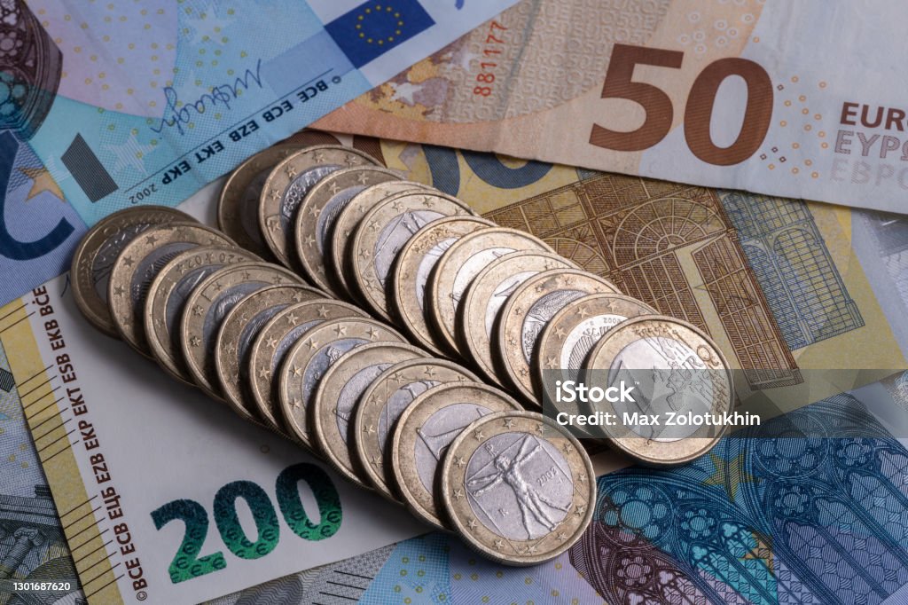 1 euro coins lie on the background of European denominations of various denominations European Union Currency Stock Photo