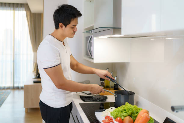 istock Asian man are using a ladle to thicken vegetable soup in a pot at the home kitchen. 1301687734