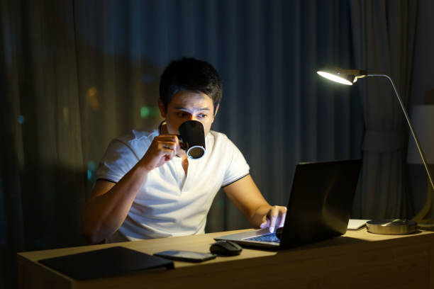 istock Asian man are drinking tea or coffee while working in late night to relieve drowsiness and make it possible to have a strong to work again. 1301687739