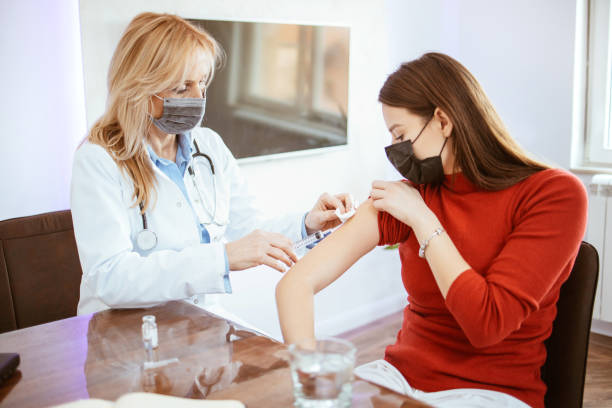 istock Young woman with face mask getting vaccinated 1301688673