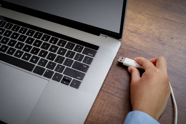 istock Hand connecting USB cable to laptop computer for connect to another device. 1301689573
