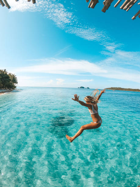 istock Woman jumping into the clear water 1301690719