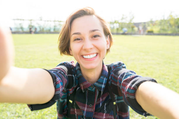 istock Young smiling woman looking at the camera (selfie / shooting) 1301694359