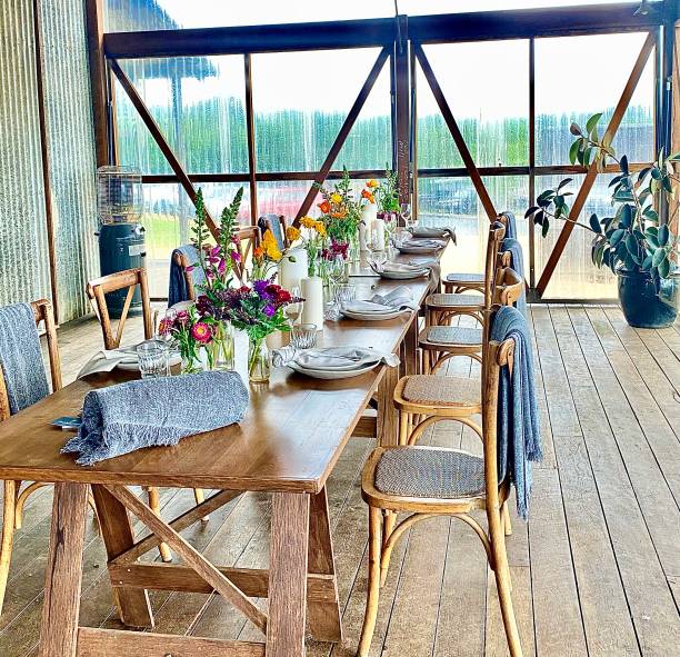 alfresco dining table at the farm byron bay - flower arrangement dining room decor dining imagens e fotografias de stock