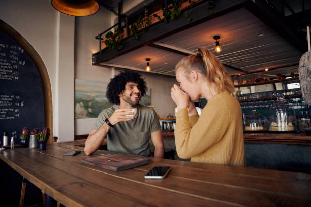 istock Handsome young man talking to woman drinking coffee in modern cafe 1301698605