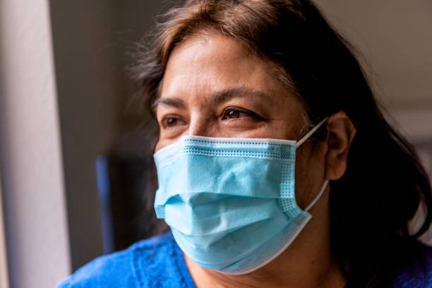 istock Mature senior hispanic woman wearing a protective face mask 1301705492