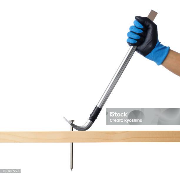 Isolated Shot Of Hand Pulling Out A Nail With A Crowbar On White Background Stock Photo - Download Image Now