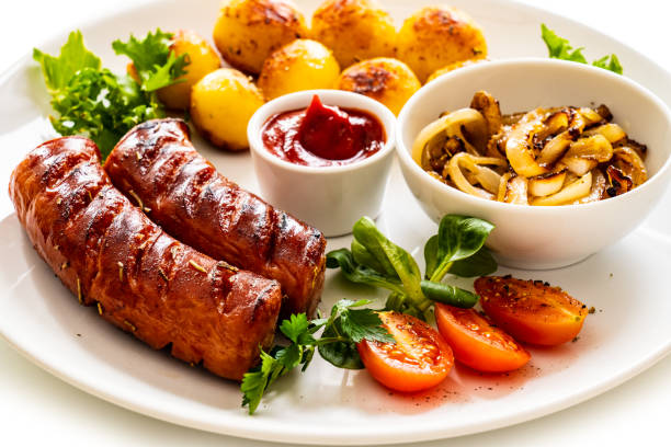 Grilled sausage and vegetables on wooden table