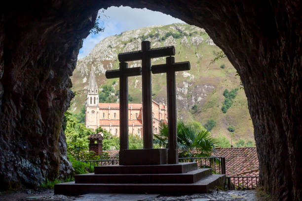 tre croci all'interno di una grotta di fronte alla cattedrale di covadonga - covadonga foto e immagini stock