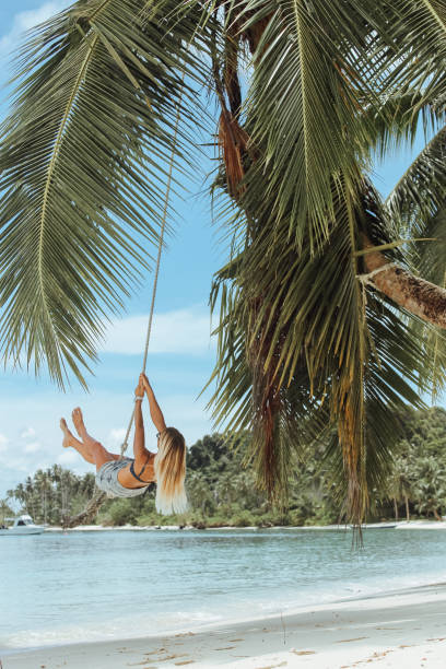 istock Woman on a swing in the tropics 1301711876