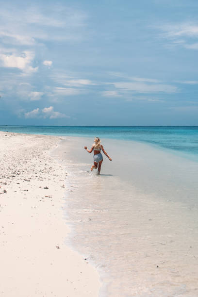 istock Woman running on a tropical beach 1301712492