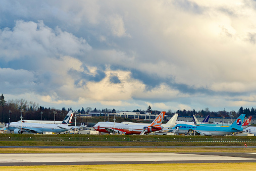 Everett, Washington, USA - February 14, 2012: Boeing 747 aircraft lined up at Boeing’s Everett Production Facility at Paine Field as a storm passes nearby.