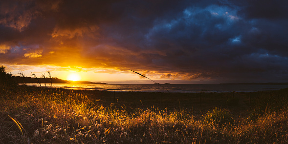 Panorama of sunrise and dramatic storm over coast, south coast, NSW, Australia
