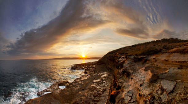 Coastal headland scene with dramatic clouds at sunset, south coast, NSW, Australia