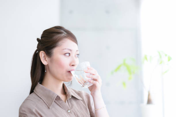 istock Young woman drinking water (image of drinking water) 1301717988