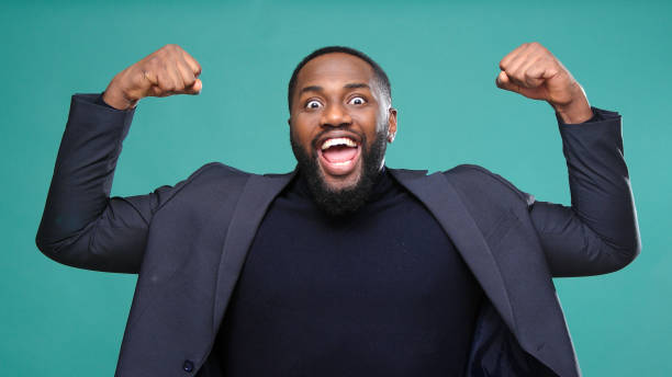 istock Smiling young man raises arms and plays muscles in studio 1301718137