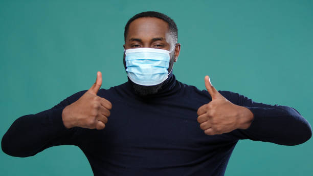 istock Gentleman in black turtleneck puts on protective facial mask 1301718658