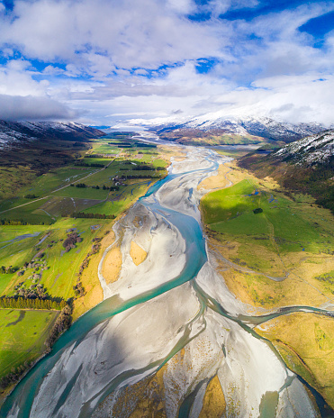 River braids and glacial snow melt run off from mountains into valley, New Zealand National Park