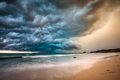 Powerful dramatic storm cell over ocean beach with golden light, Australia