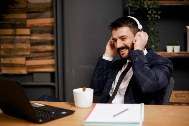 istock Young businessman with headphones singing at work 1301720572