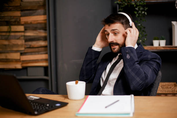 istock Young businessman with headphones singing at work 1301720593