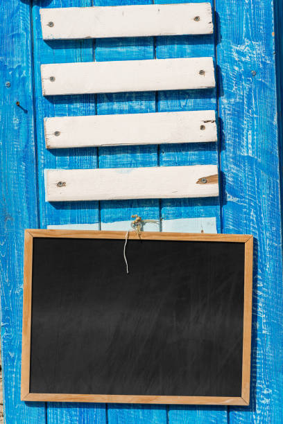 Closeup of a wooden blank billboard and empty blackboard with copy space. Template for a Bar, Restaurant, Pub, Pizzeria, Tavern or a rustic Shop.