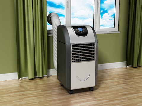 Generic portable air conditioner standing near the window in the room.