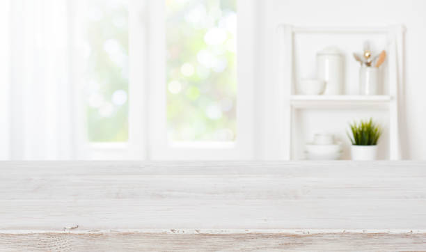 istock Bleached wooden table top on blurred kitchen summer window background 1301725724