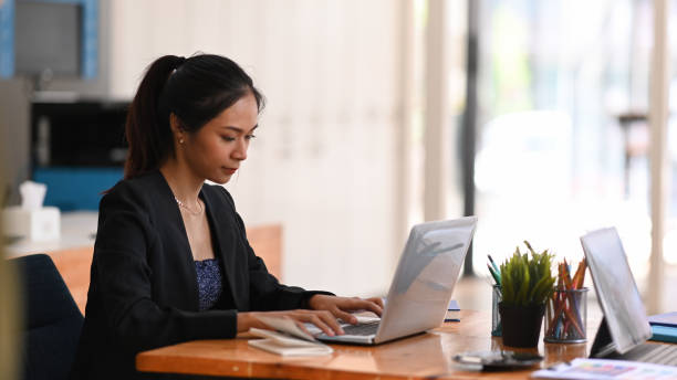 istock Young asian businesswoman working on her project with laptop computer while sitting a office desk. 1301725737